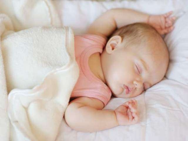 Dùng khăn quấn người bé khi ngủ giường tạo cảm giác an toàn